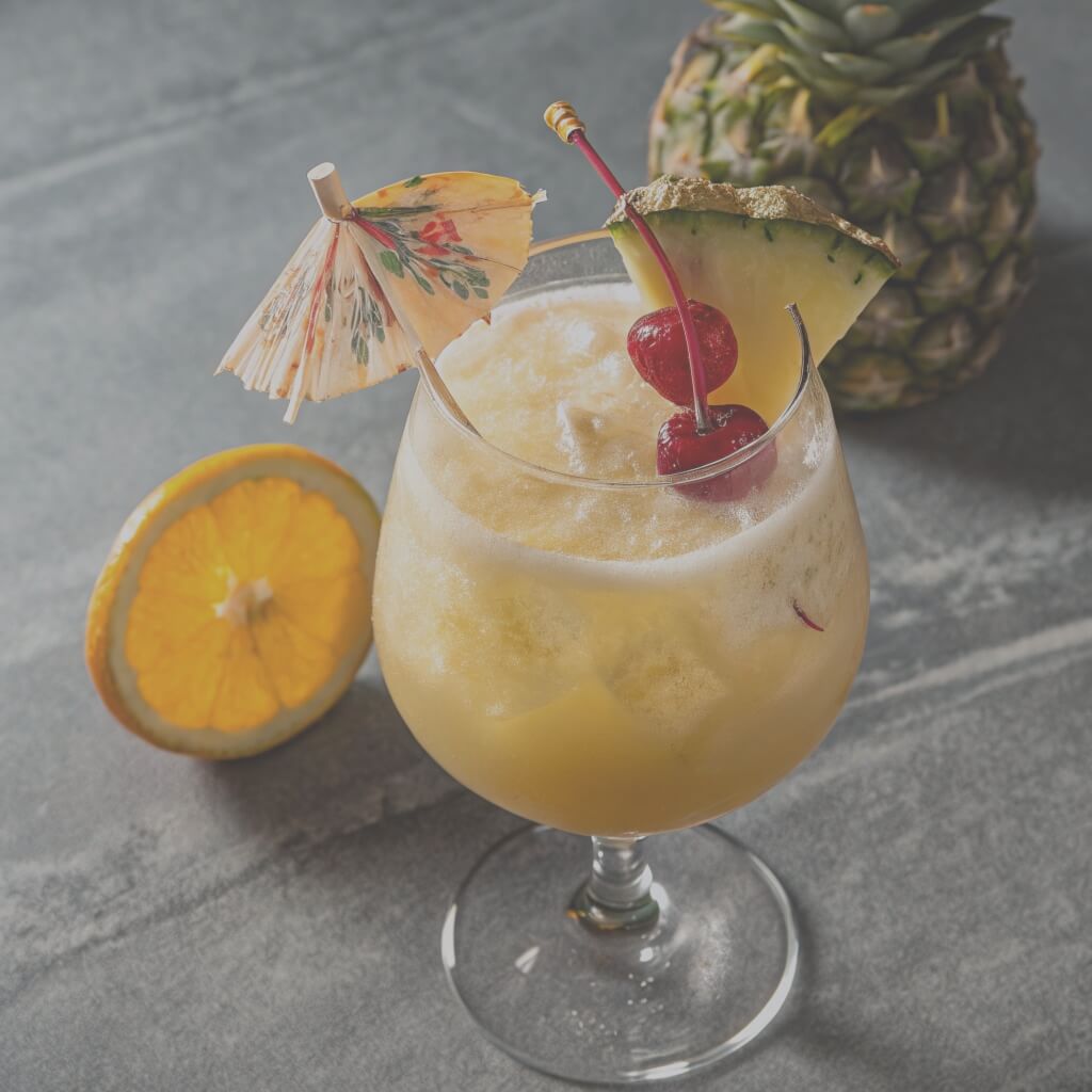 A colorful drink garnished with a pineapple slice and a cherry on top, served in a tall glass.