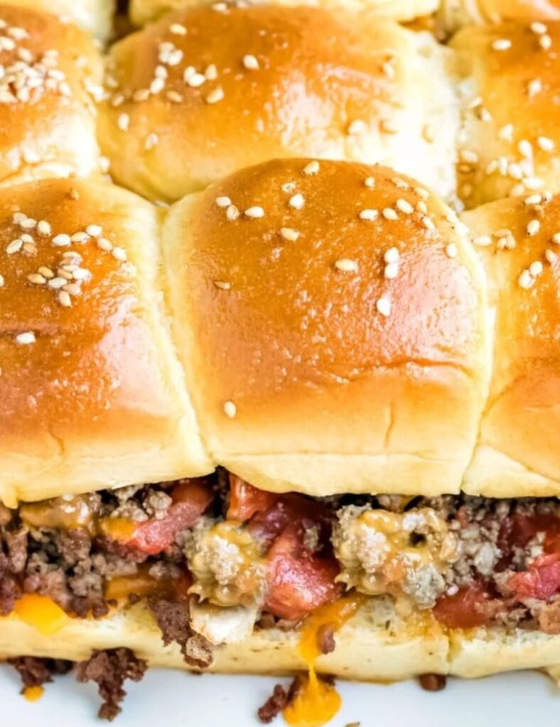 A hamburgere topped with cheese and peppers, served on a white plate.