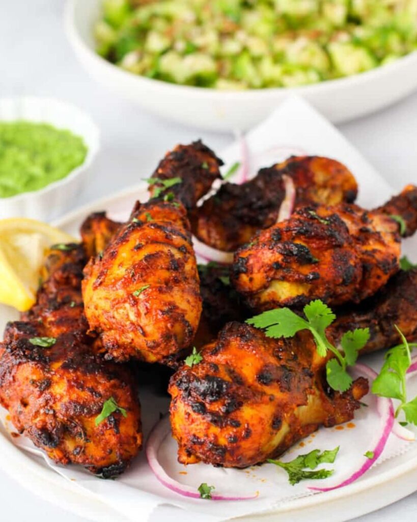 Chicken tikka masala served on a white plate, garnished with cilantro and accompanied by rice.