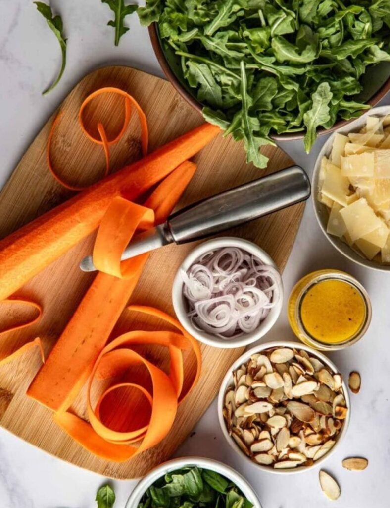 Fresh vegetables and herbs arranged on a wooden cutting board, ready for salad preparation.