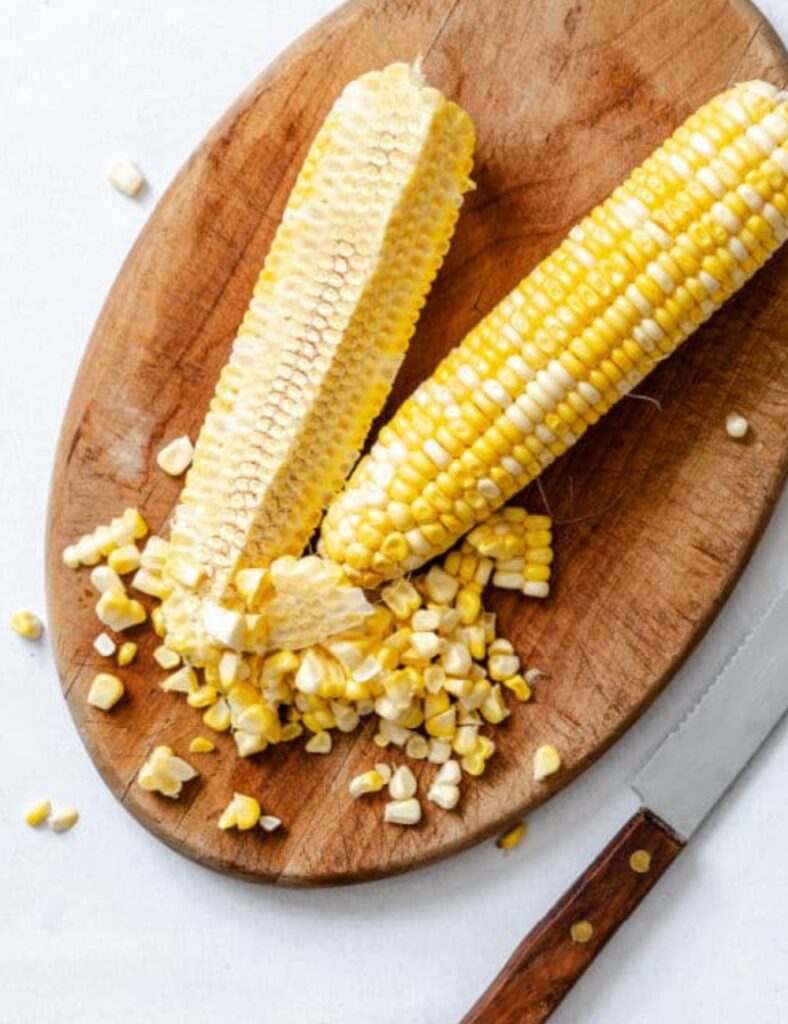 a corn on the cob on a wooden board