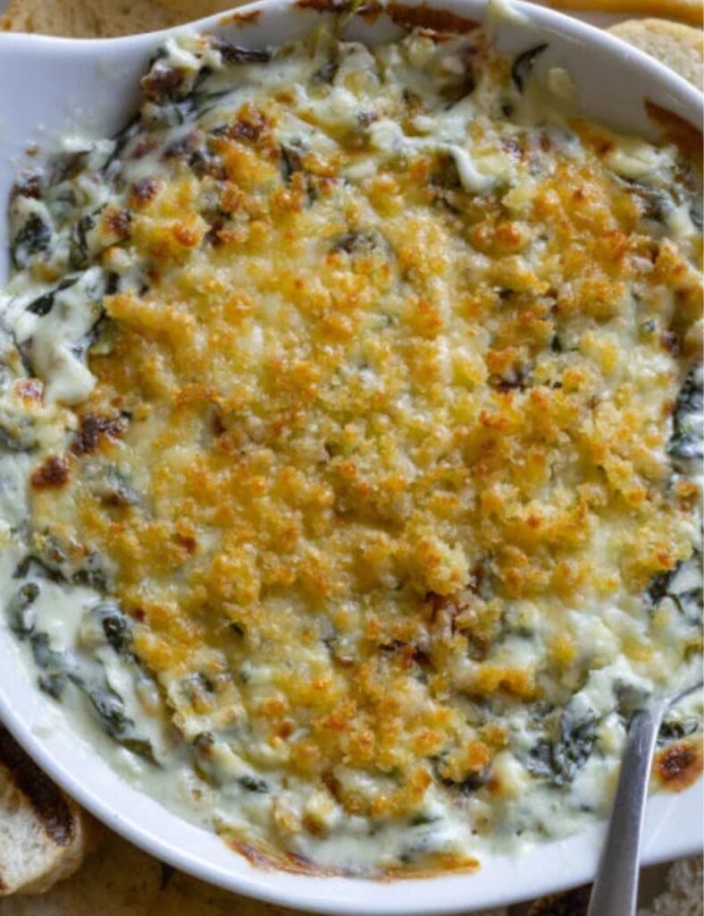 Spinach and cheese dip served in a white dish, garnished and ready for serving.