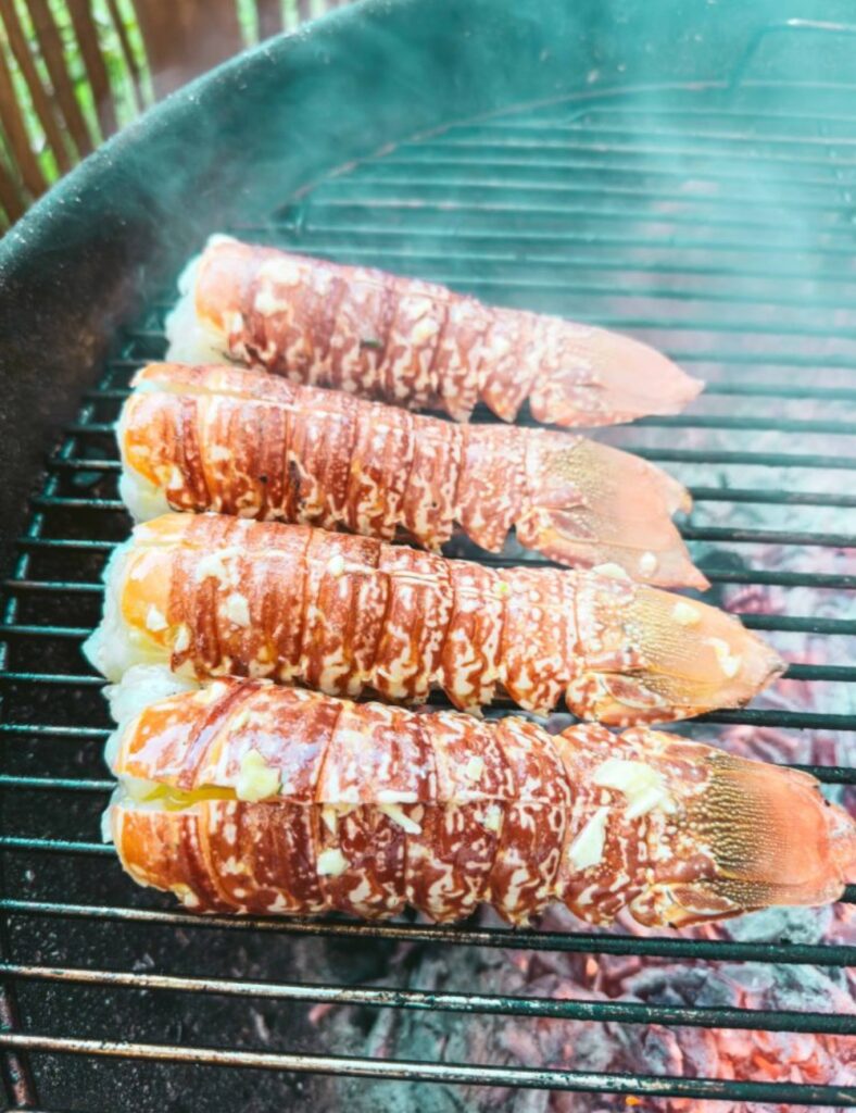Lobster grilling on a barbecue, showcasing its vibrant red color and charred texture.