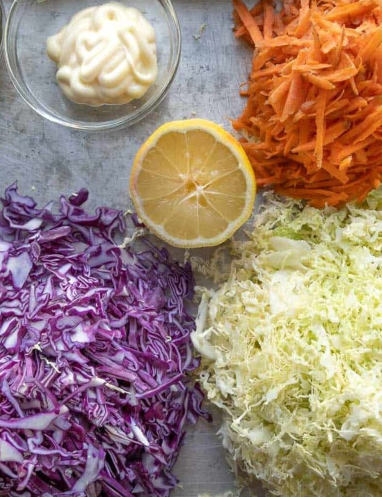 1 small head of green cabbage, shredded
1 small head of red cabbage, shredded
2 large carrots, grated
1 cup mayonnaise
2 tablespoons apple cider vinegar
1 tablespoon sugar
Salt and pepper to taste