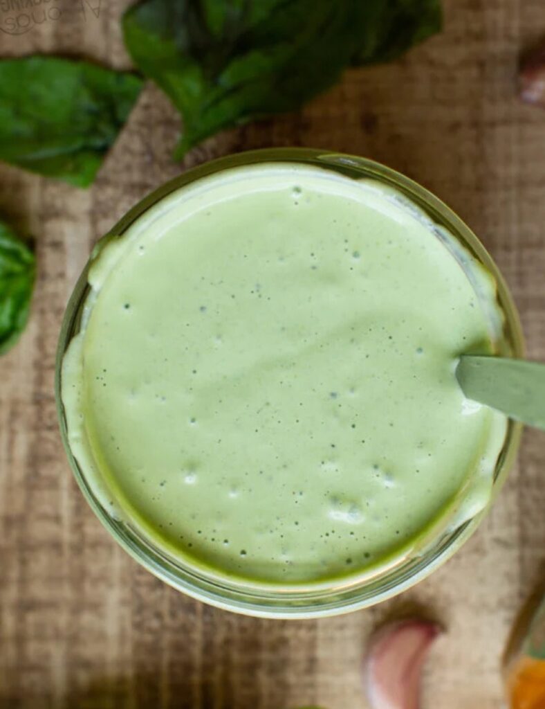 Close-up of a glass jar filled with a creamy dressing, showcasing its smooth texture and vibrant color.