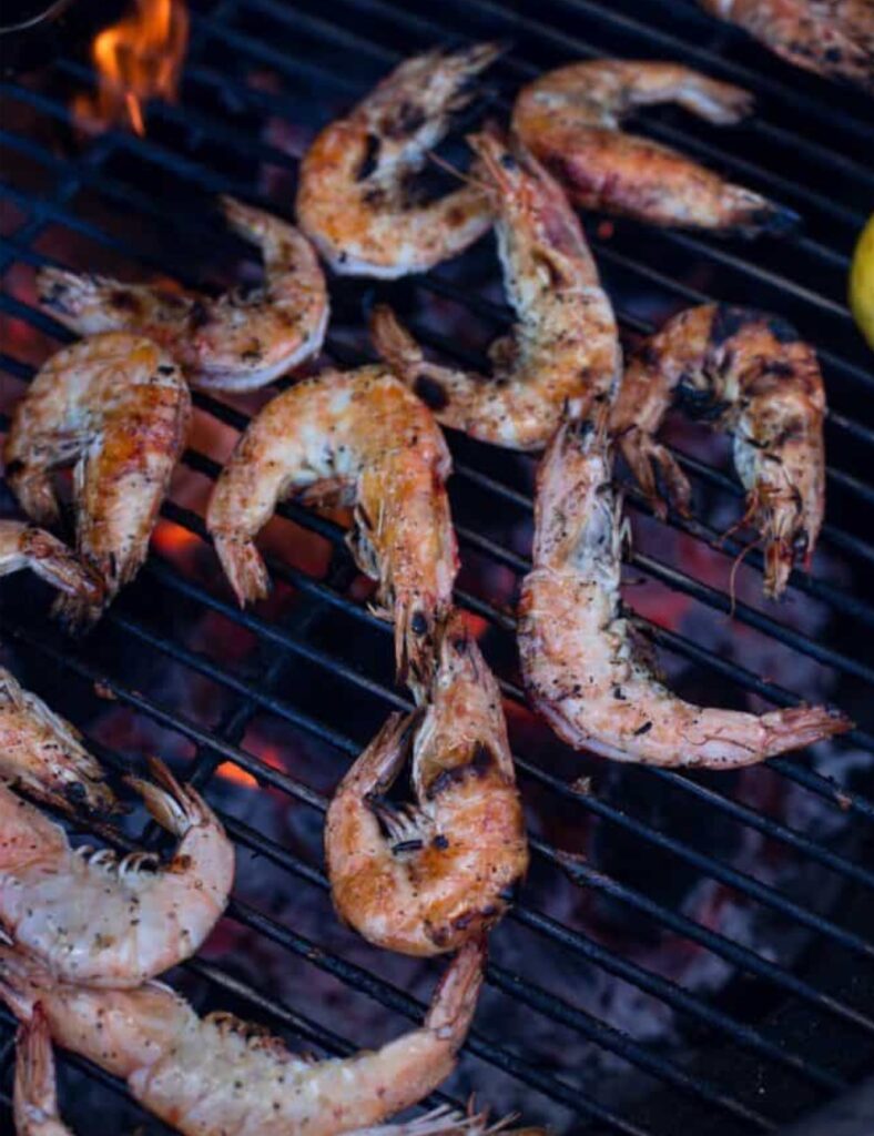 Place the skewered prawns on the grill. Grill for about 2-3 minutes on each side, or until they turn pink and are opaque in color.