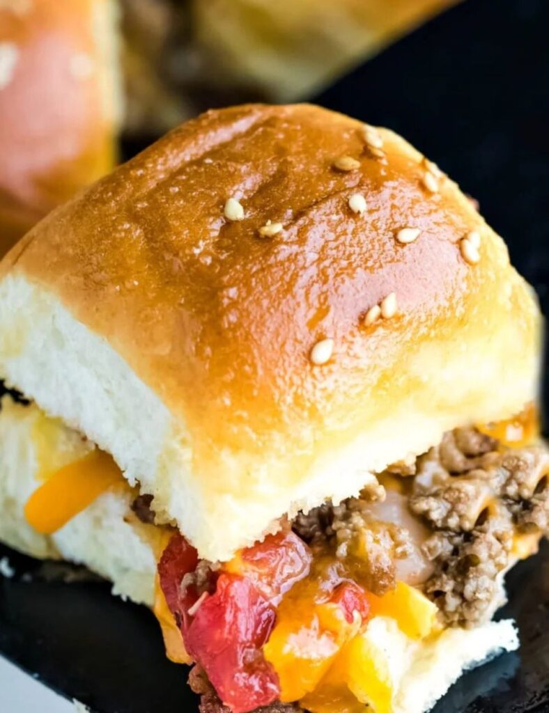 A hamburger topped with cheese and peppers, served on a white plate.