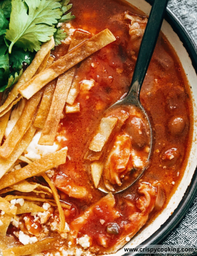 Mexican chicken soup served in a bowl, featuring vibrant vegetables and spices, garnished with fresh herbs.