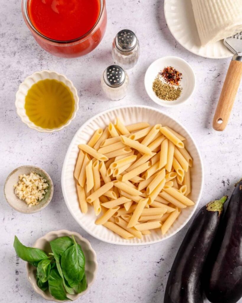 400g of pasta (rigatoni or spaghetti)
2 medium eggplants
400g of canned tomatoes
2 garlic cloves
Olive oil
Salt
Pepper
Fresh basil
Grated ricotta salata cheese (optional)