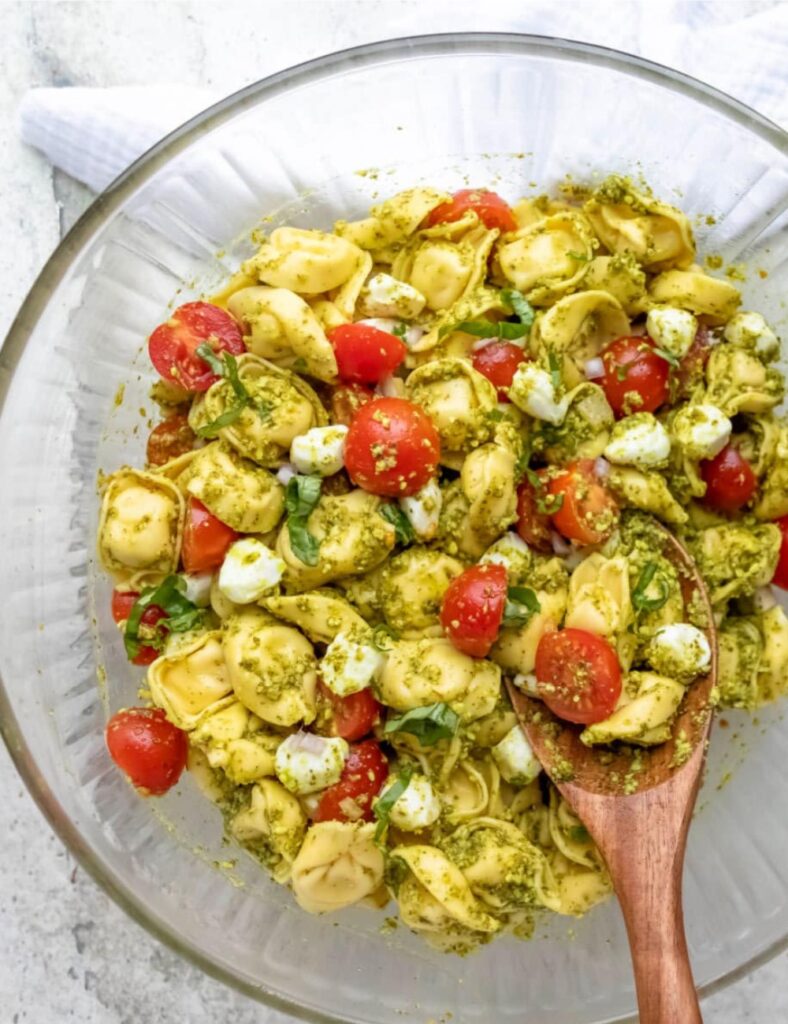 Pesto tortellini pasta salad with fresh vegetables and herbs