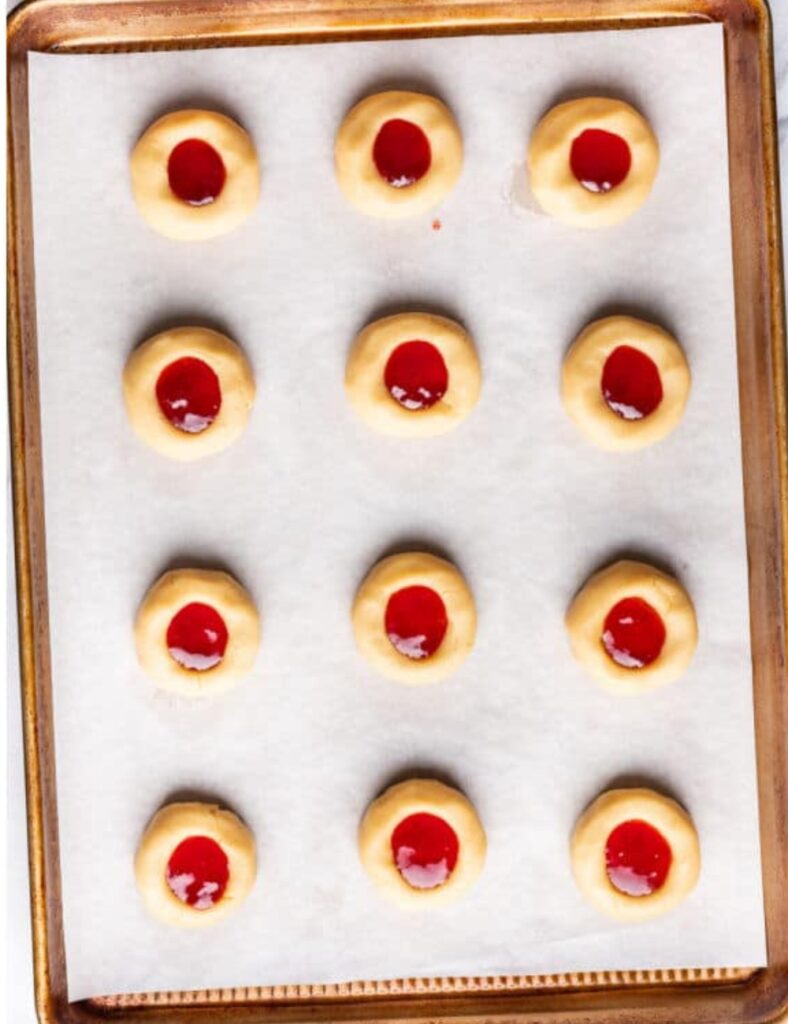 Baking sheet filled with freshly baked cookies, golden brown and arranged in neat rows.