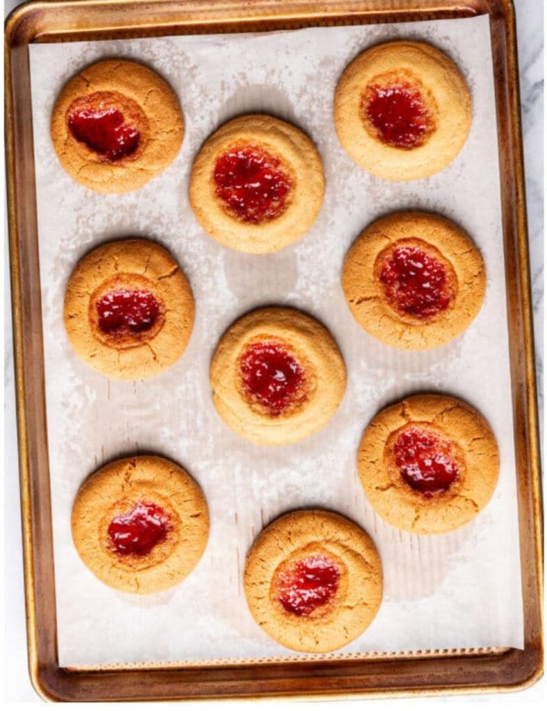 Baking sheet filled with freshly baked cookies, golden brown and slightly cooling.