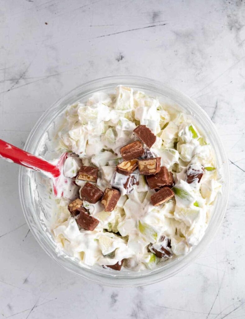 Delicious Snickers Salad with apples, caramel, and whipped cream