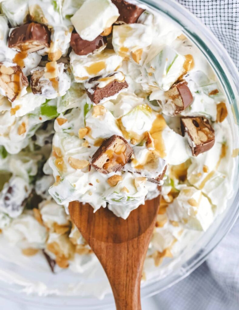Delicious Snickers Salad with apples, caramel, and whipped cream