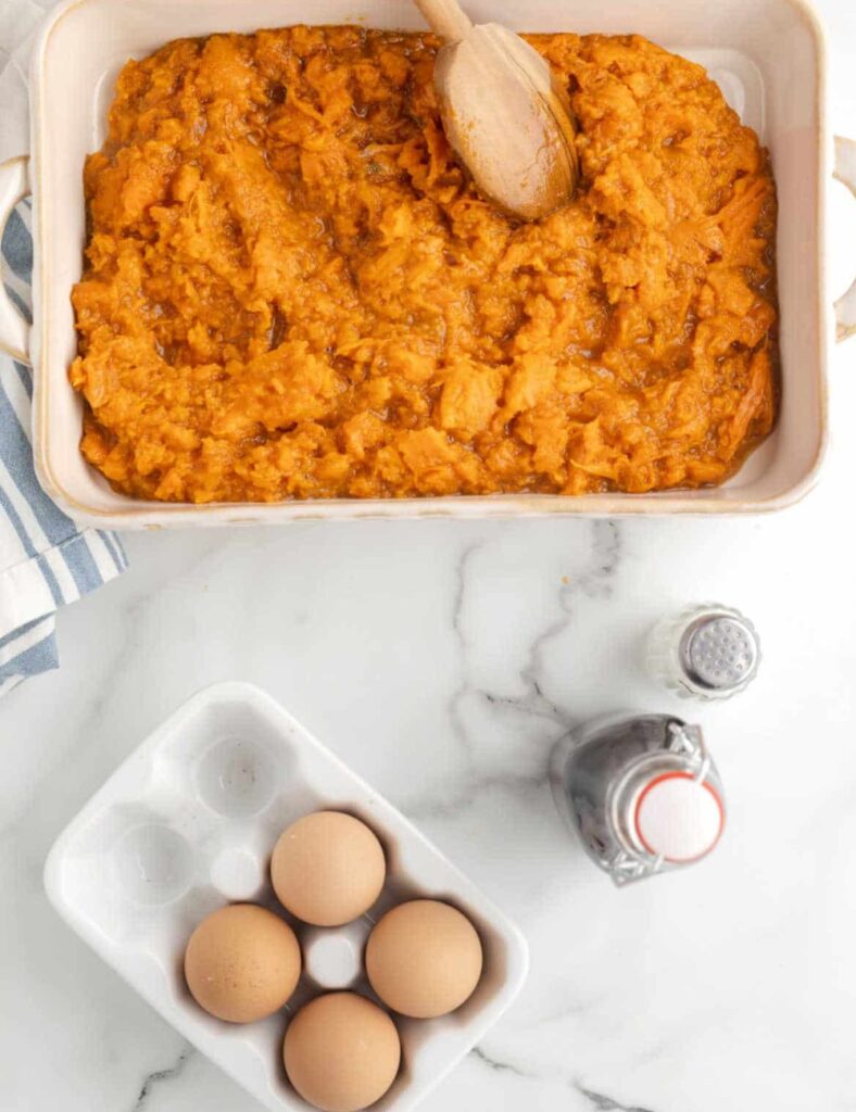 Add the brown sugar, melted butter, milk, vanilla extract, and salt to the mashed sweet potatoes. Mix everything together until it's smooth and well incorporated.