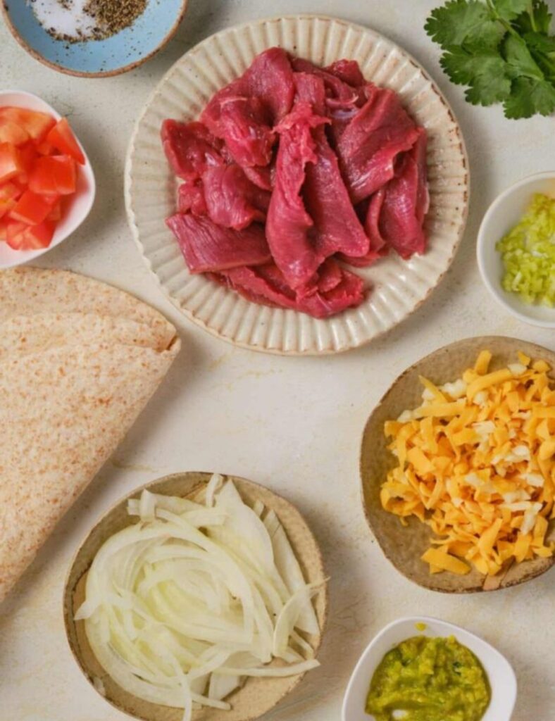 Corn tortillas
Cheese (such as Oaxaca or Chihuahua cheese)
Meat (such as carne asada, or chicken)
Onion (chopped)
Cilantro (chopped)
Salsa
Lime wedges