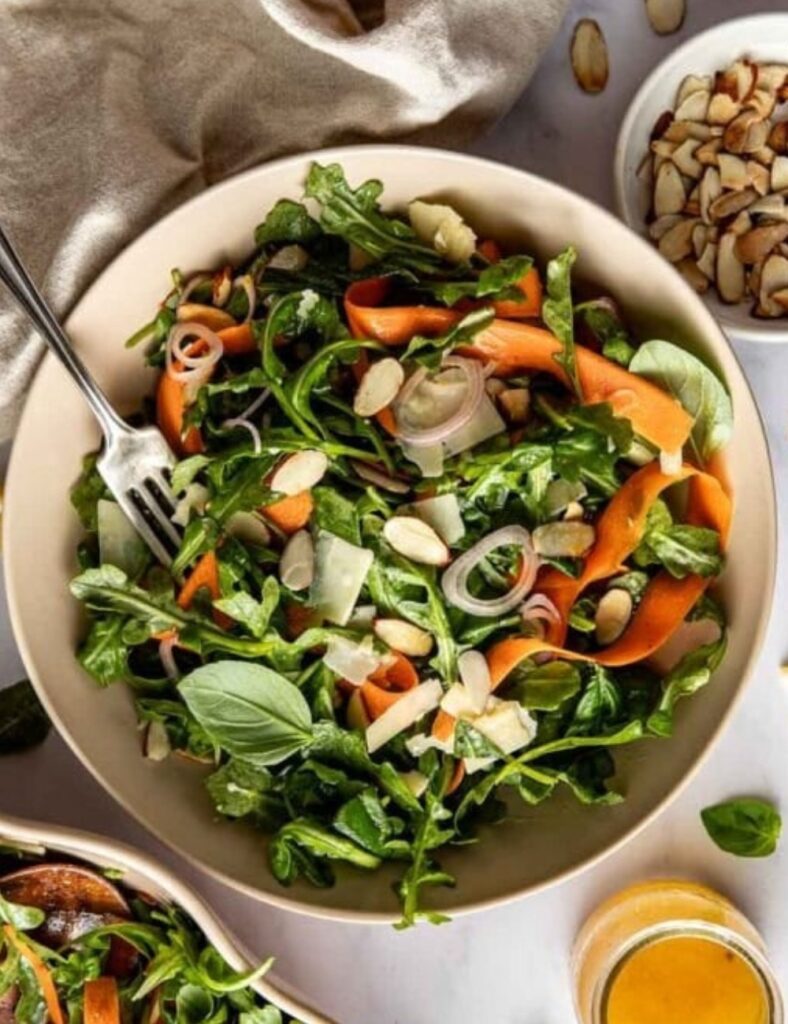 Salad featuring fresh greens, sliced carrots, and crunchy almonds.