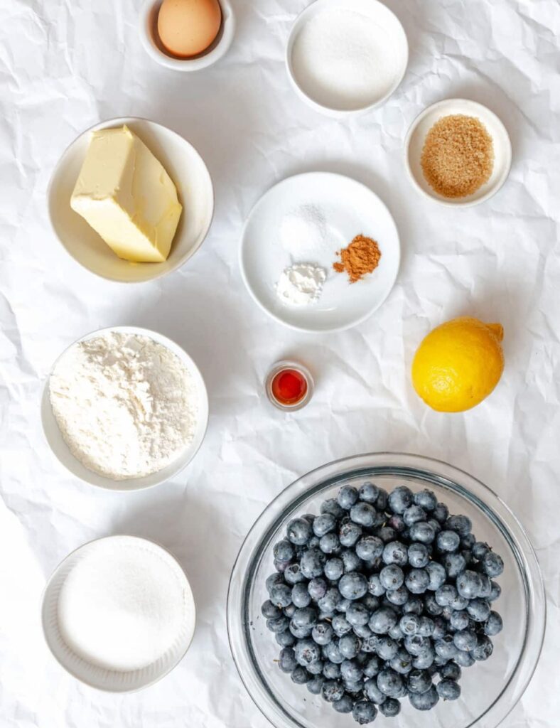a blueberry pie ingredients on a white surface