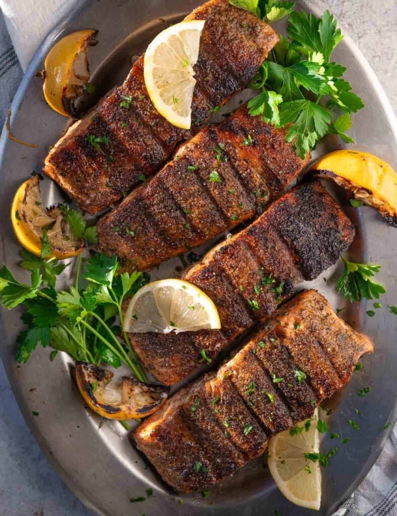 a plate of food with lemons and parsley
