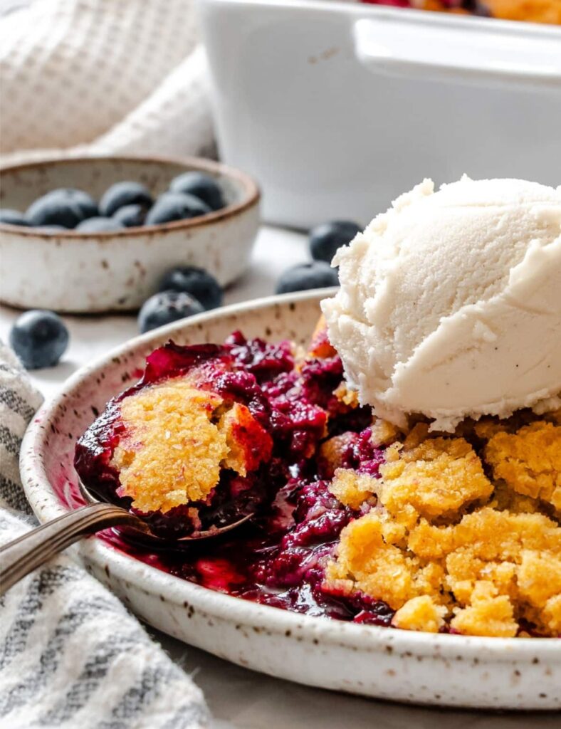 a plate of food with a spoon and ice cream