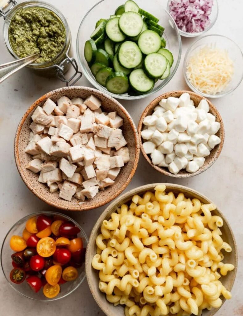 2 cups cooked pasta
1 cup cooked chicken, diced
1/2 cup pesto sauce
1 cup cherry tomatoes, halved
1/2 cup mozzarella balls, halved
1/4 cup grated Parmesan cheese
Salt and pepper to taste
Fresh basil for garnish