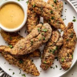 Air fryer chicken tenders served with dipping sauce on a plate