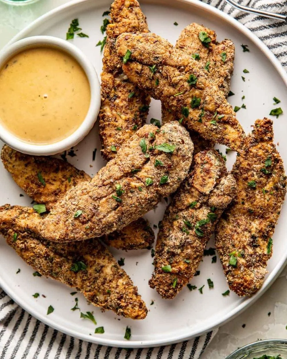 Air fryer chicken tenders served with dipping sauce on a plate
