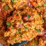 Delicious Cajun sausage and rice served in a bowl with fresh herbs.