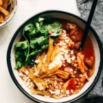 Bowl of delicious Chicken Tortilla Soup topped with tortilla strips and fresh herbs