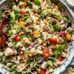Chopped Mediterranean salad with chicken and fresh vegetables in a bowl.