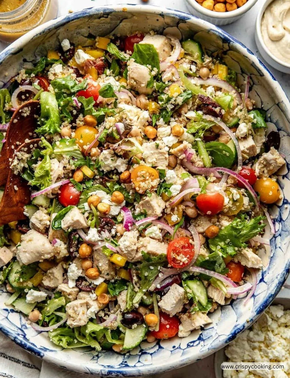 Chopped Mediterranean salad with chicken and fresh vegetables in a bowl.