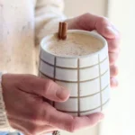 Cinnamon Coconut Latte served in a cup with spices and coconut flakes