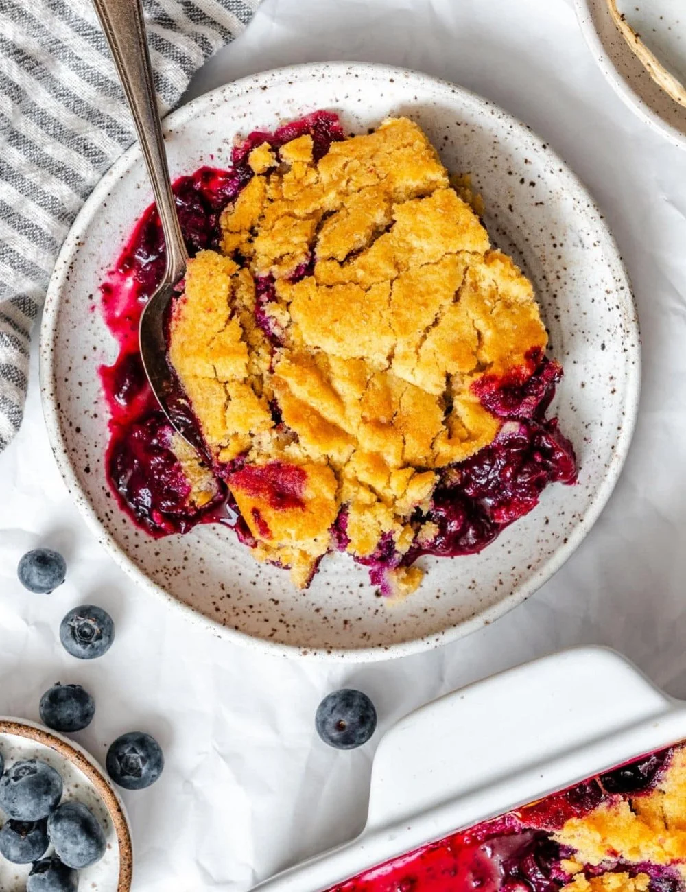 Easy blueberry cobbler fresh from the oven with blueberries on top.