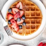 Fluffy and golden easy buttermilk waffles served with syrup and berries