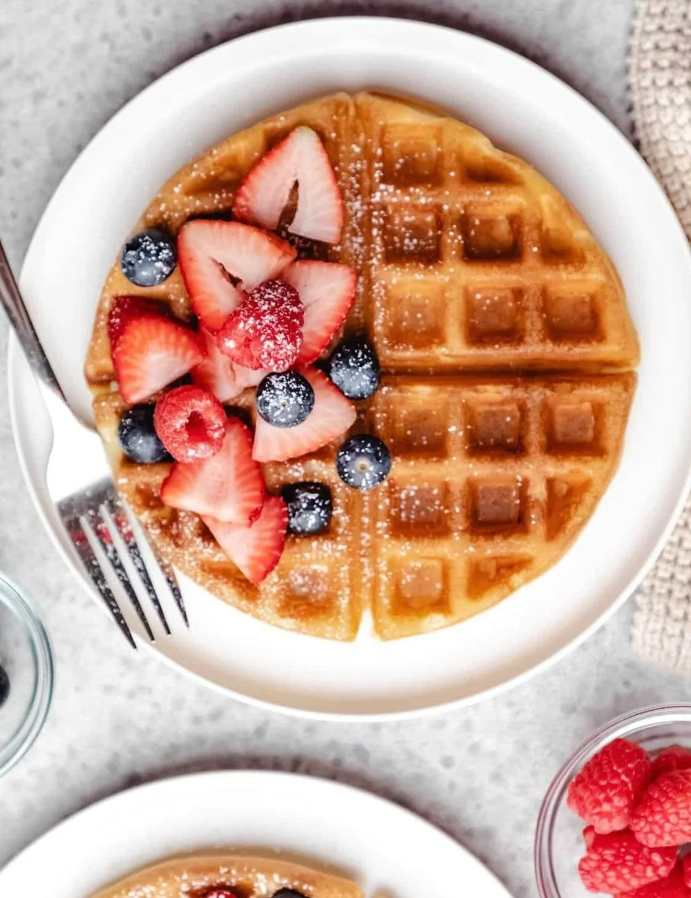 Fluffy and golden easy buttermilk waffles served with syrup and berries