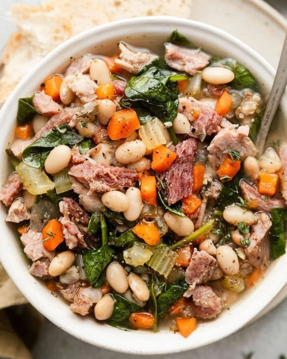 Bowl of easy ham and bean soup garnished with herbs