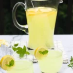 A refreshing glass of fresh ginger lemonade with slices of lemon and ginger.
