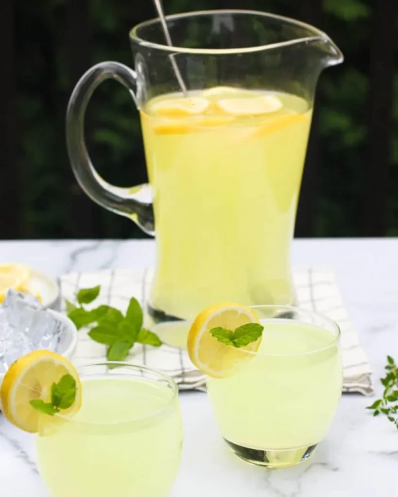 A refreshing glass of fresh ginger lemonade with slices of lemon and ginger.