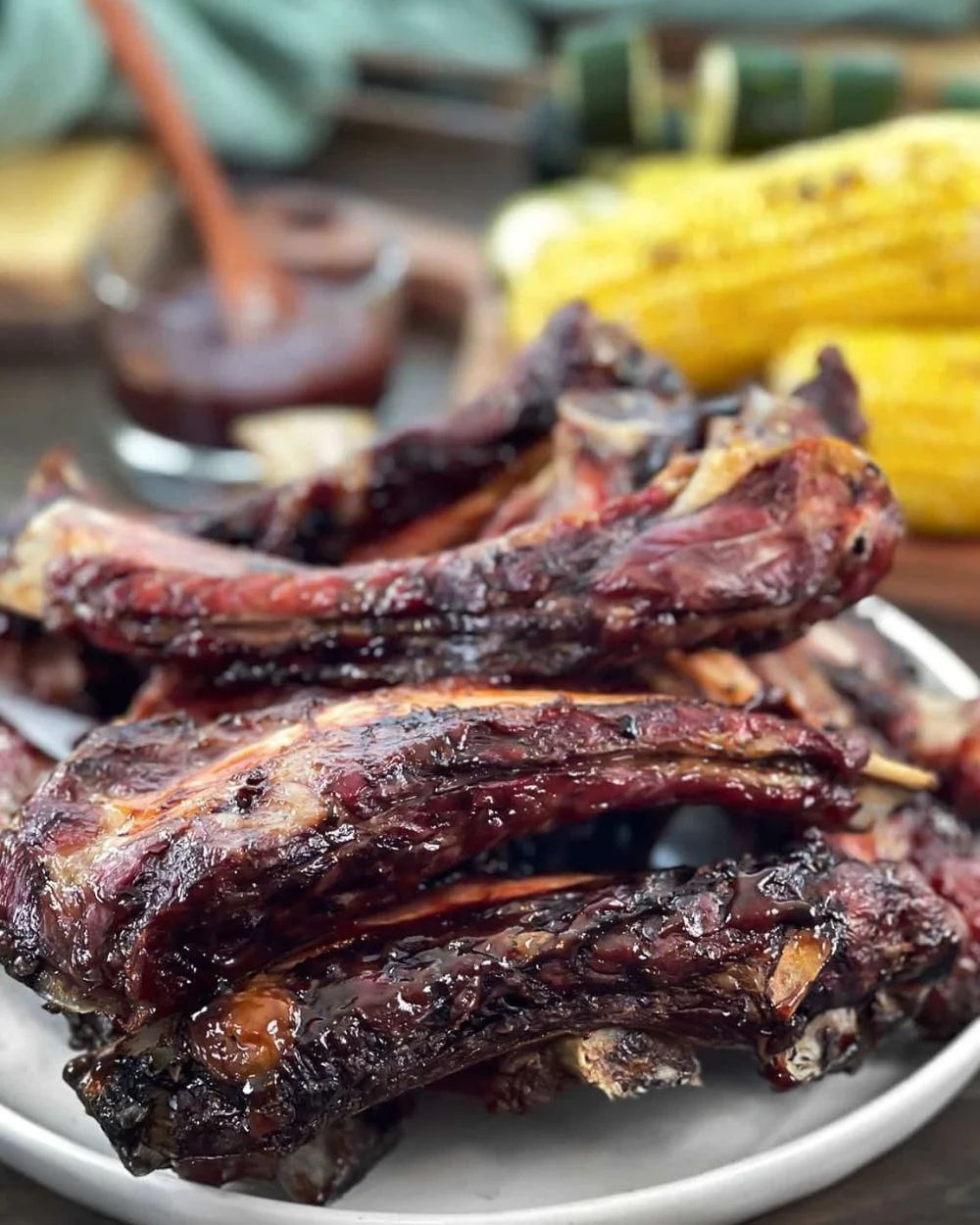 Juicy grilled beef ribs served with barbecue sauce and side dishes