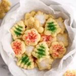 Colorful holiday spritz cookies arranged on a festive plate.