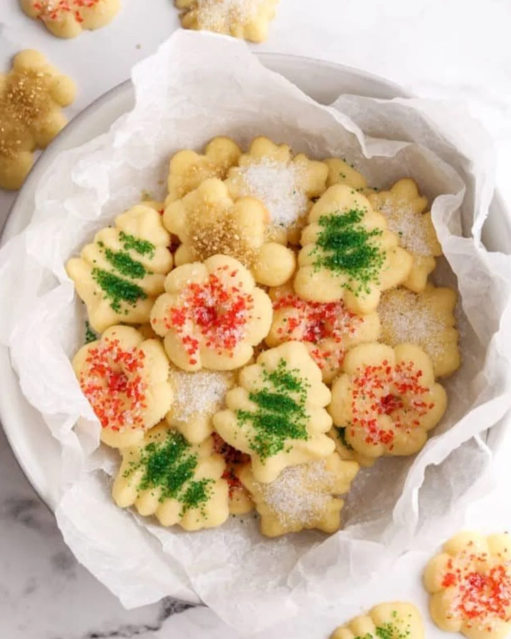 Colorful holiday spritz cookies arranged on a festive plate.