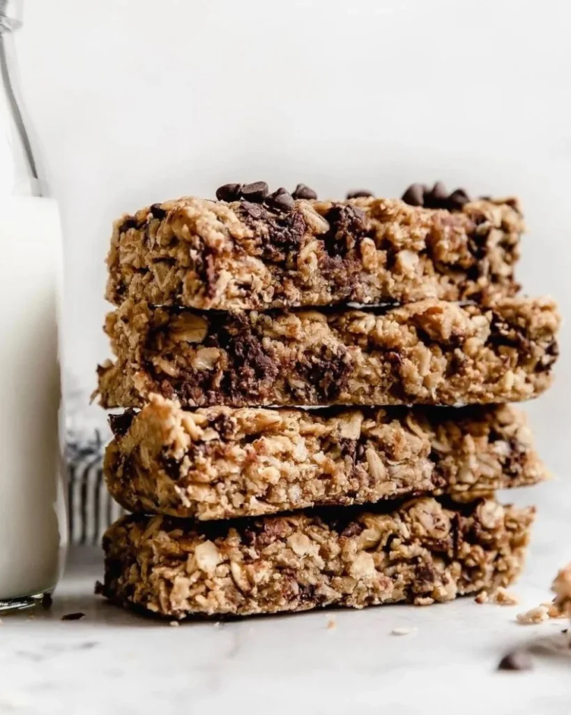 Healthy homemade peanut butter granola bars stacked on a wooden table.
