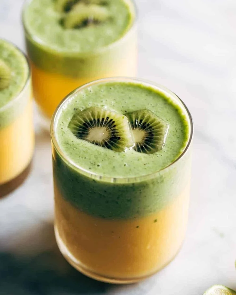Refreshing Mango Kiwi Coolers served in a glass with ice and fruit slices