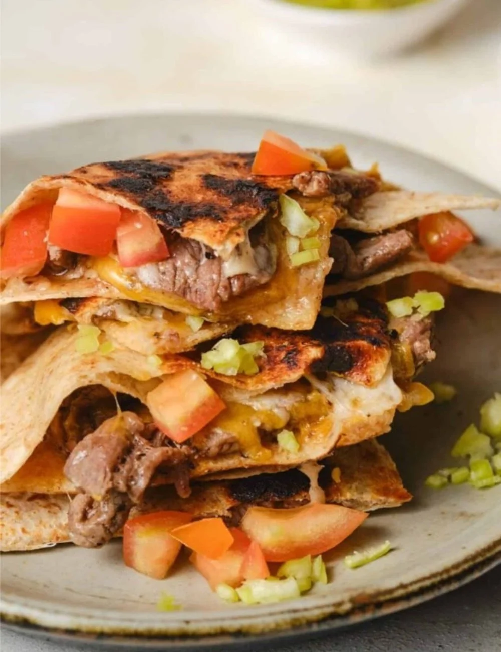 Deliciously stacked mulitas with savory meat, cheese, and salsa on a warm tortilla.