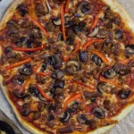 Homemade pizza cooked on a pellet grill with smoky flavor and crispy crust.