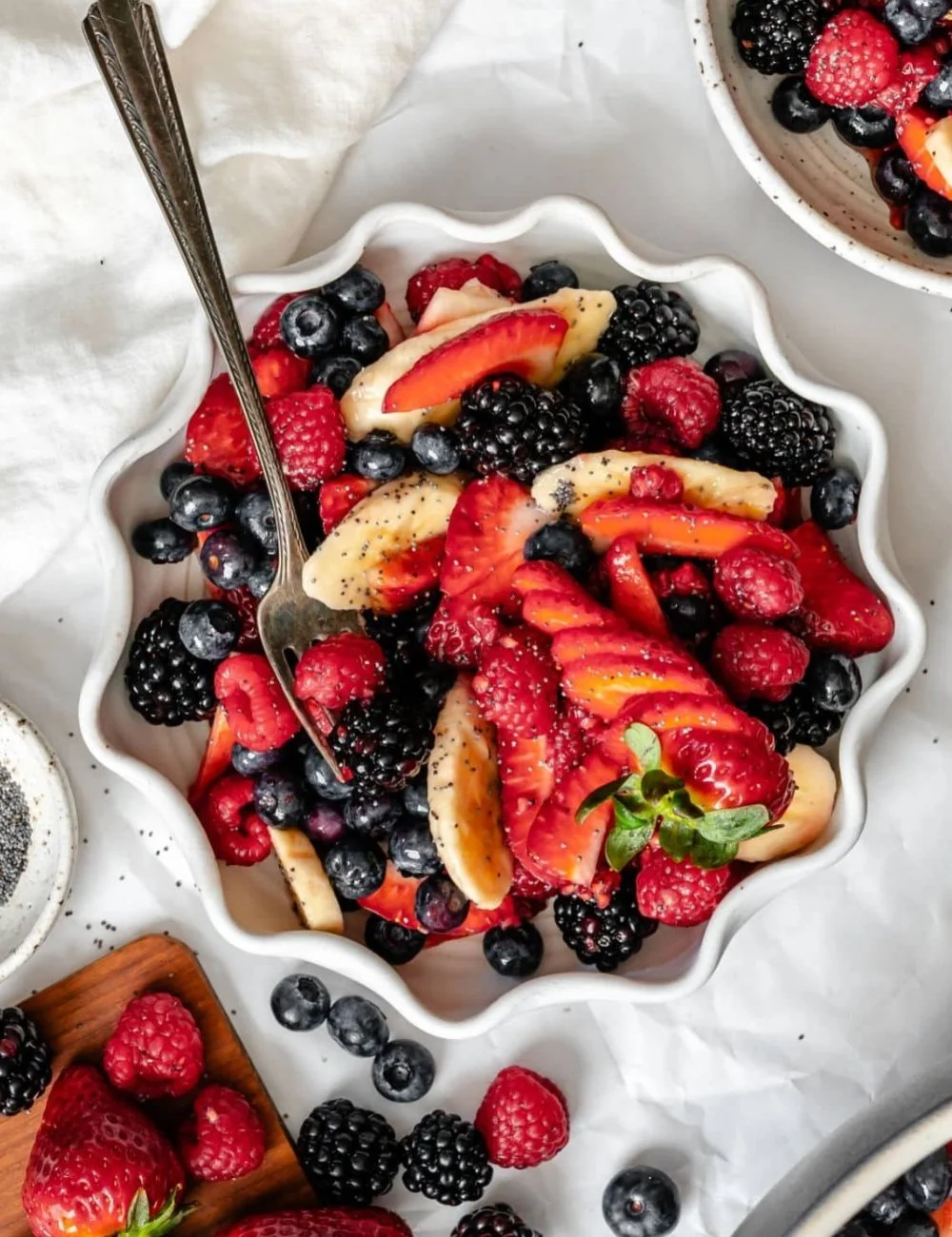 A colorful poppy seed fruit salad featuring various fresh fruits and a light dressing.