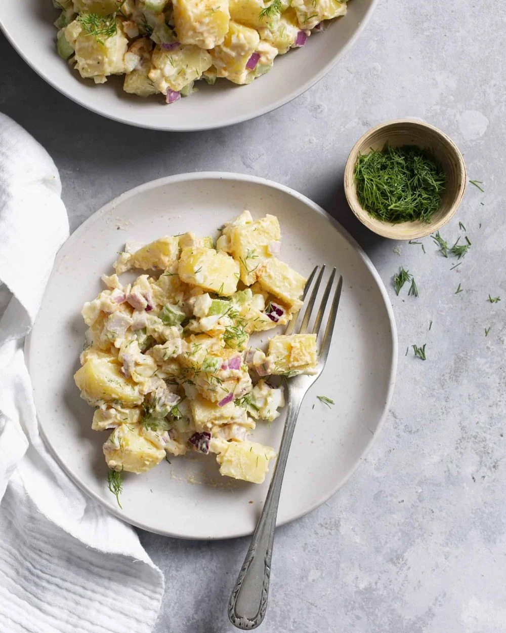 Delicious and creamy potato salad served in a bowl, garnished with herbs.