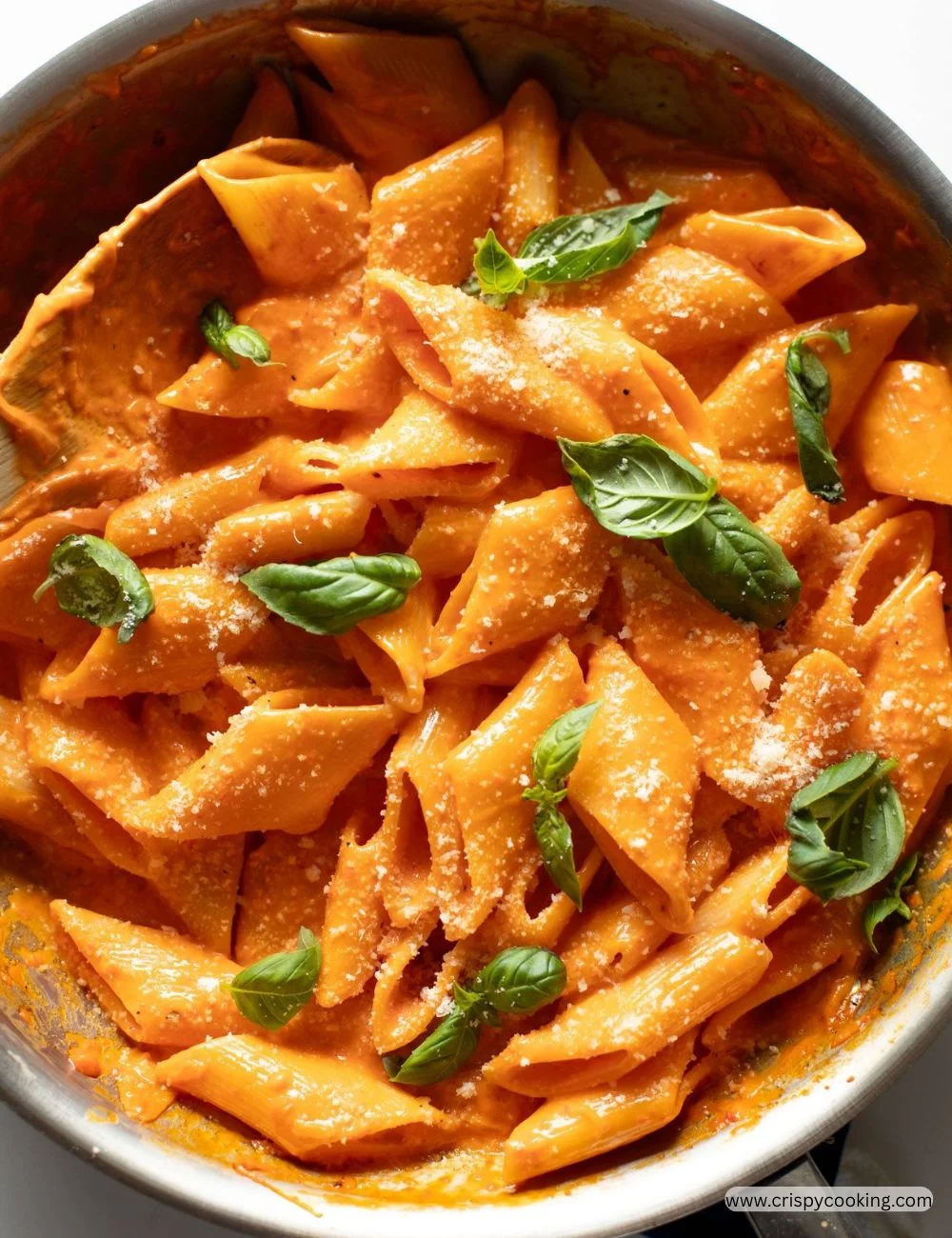 Plate of creamy roasted red pepper pasta garnished with fresh herbs
