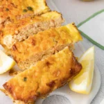 Baked salmon loaf garnished with herbs and lemon slices for a delicious presentation