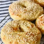 Freshly baked sesame bagels with a golden crust and sesame seeds on top.